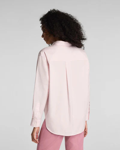 Person wearing a light pink SPANX shirt and pink pants against a gray background