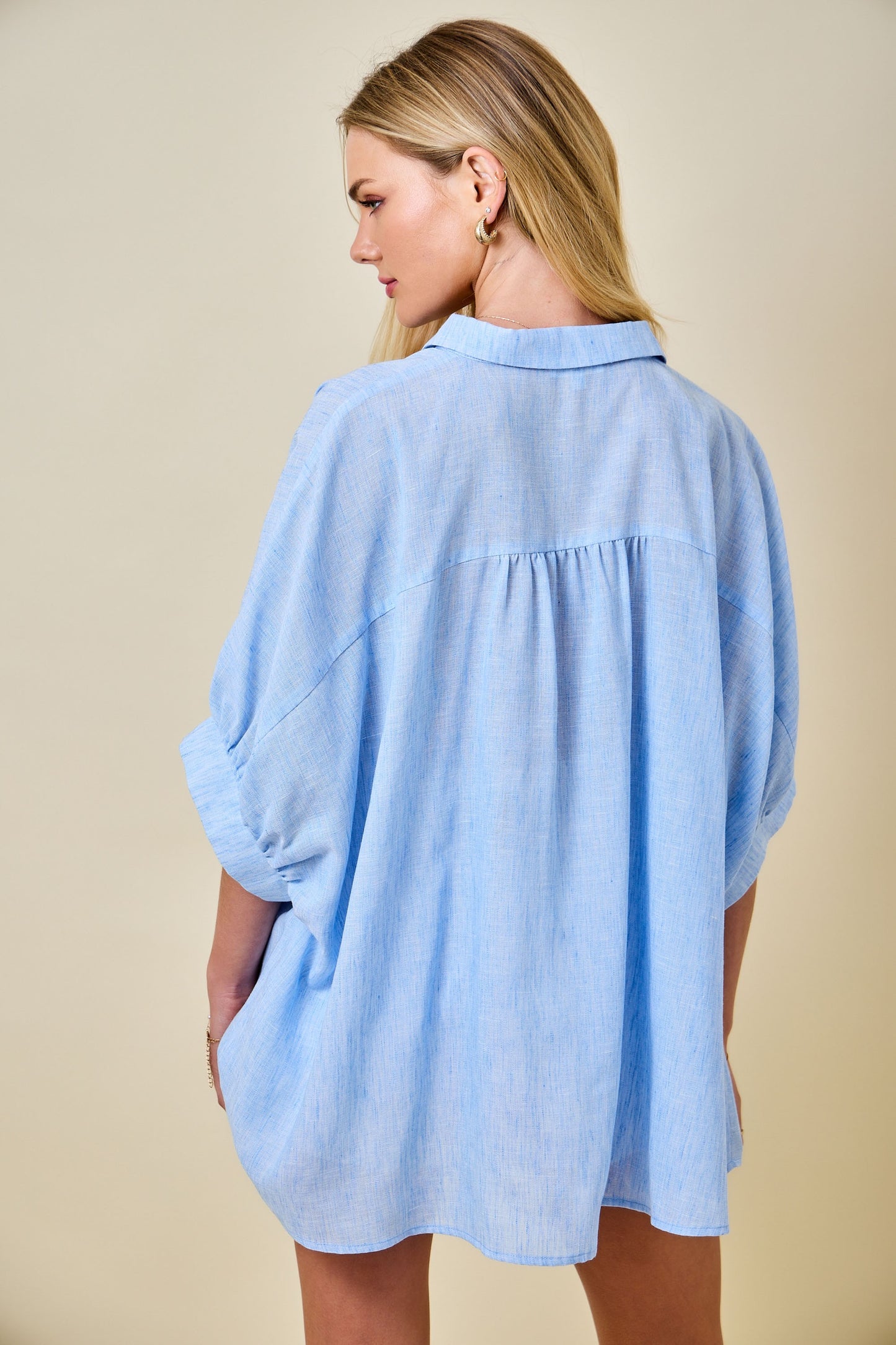 Woman wearing a light blue shirt against a beige background