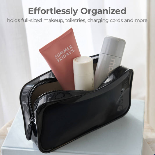 A glossy black zippered makeup bag sits open on a white surface, holding a pink tube labeled 'SUMMER FRIDAYS.' and other toiletries, with text at the top reading 'Effortlessly Organized' and a subtitle about holding full-sized makeup, toiletries, and charging cords.