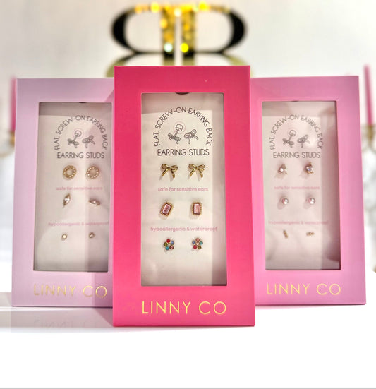 Three pink boxes of Linny Co earrings on a white background