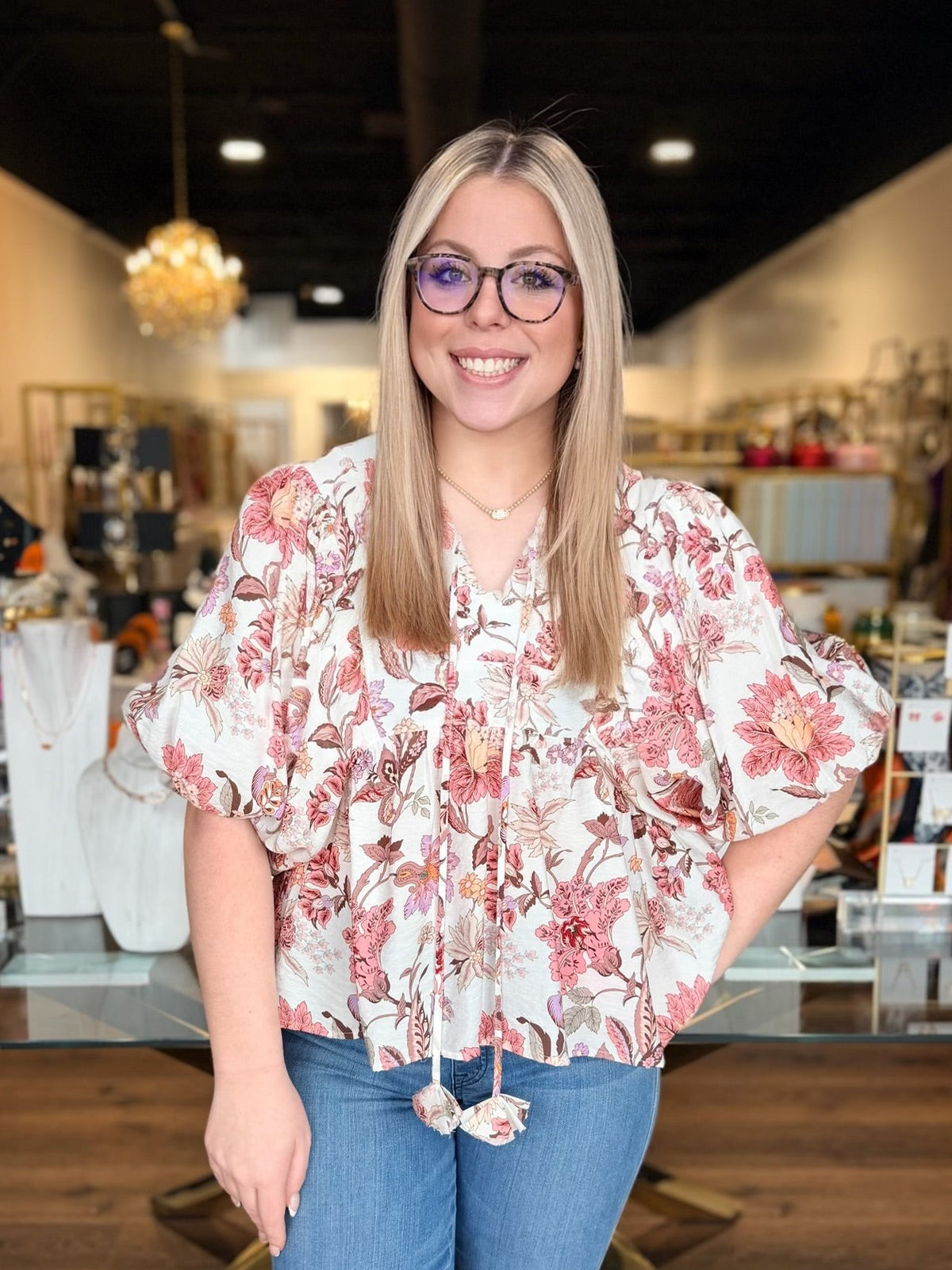 model wearing pink flower top with denim jeans