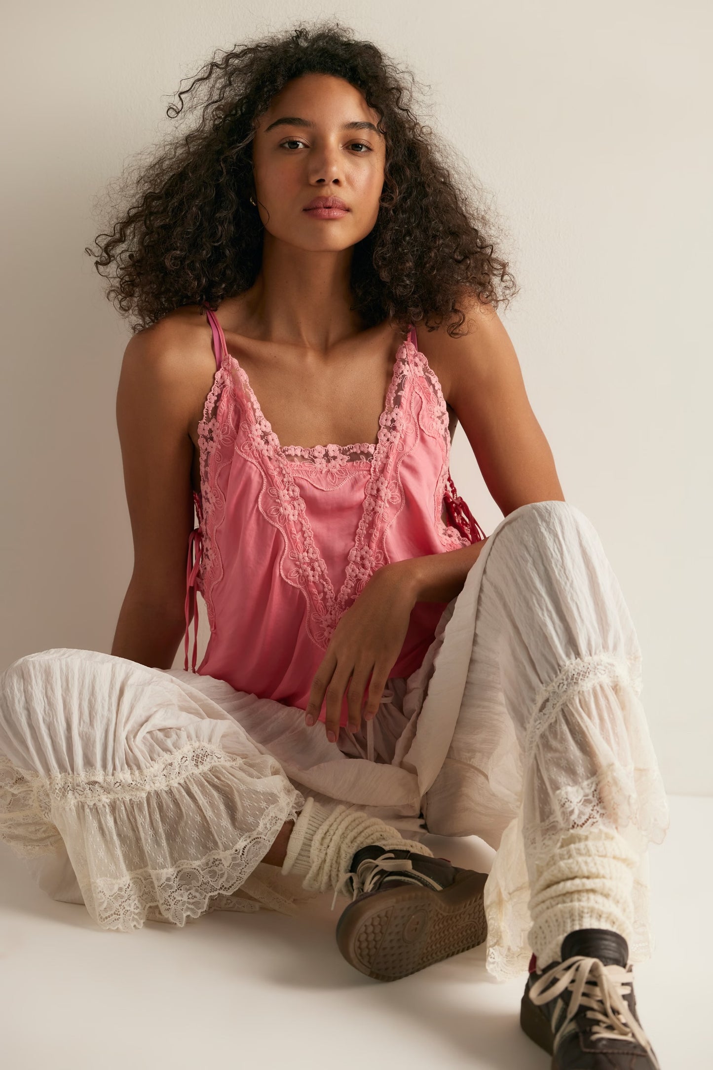 women wearing pink lace tank top sitting down