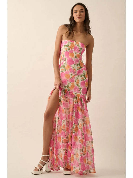 Woman wearing a floral strapless dress with a slit on a beige background