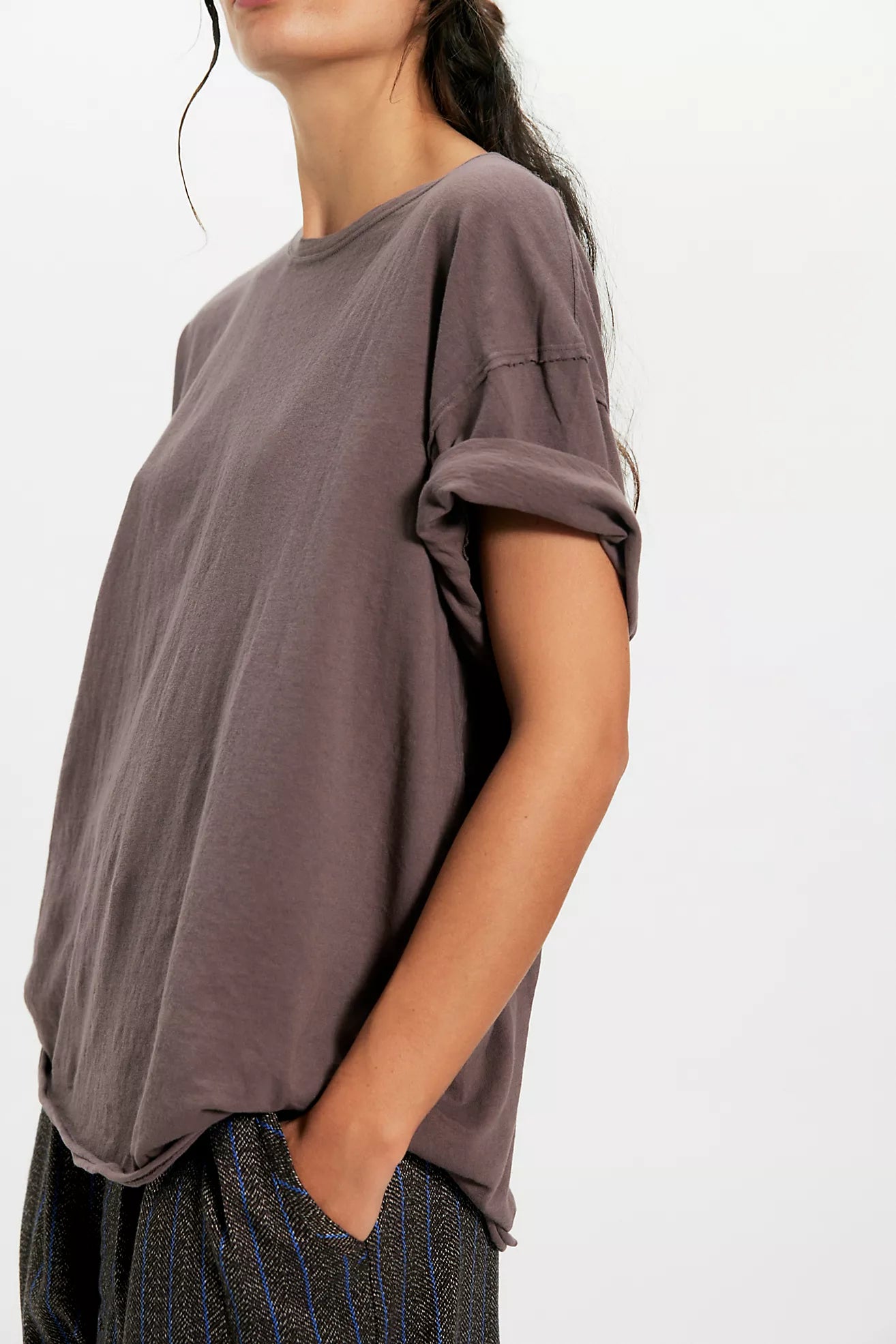 Person wearing a loose-fitting brown t-shirt on a white background