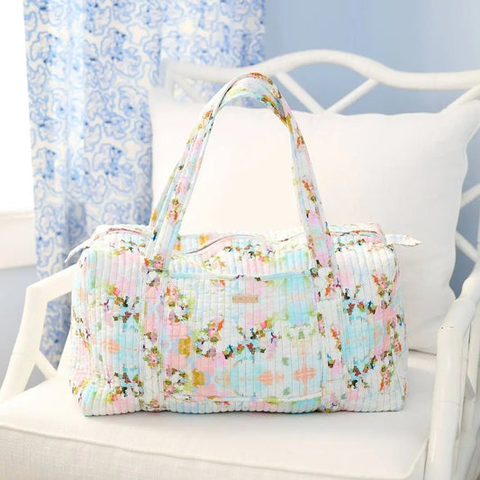 Floral patterned bag on a white chair with a light blue curtain background