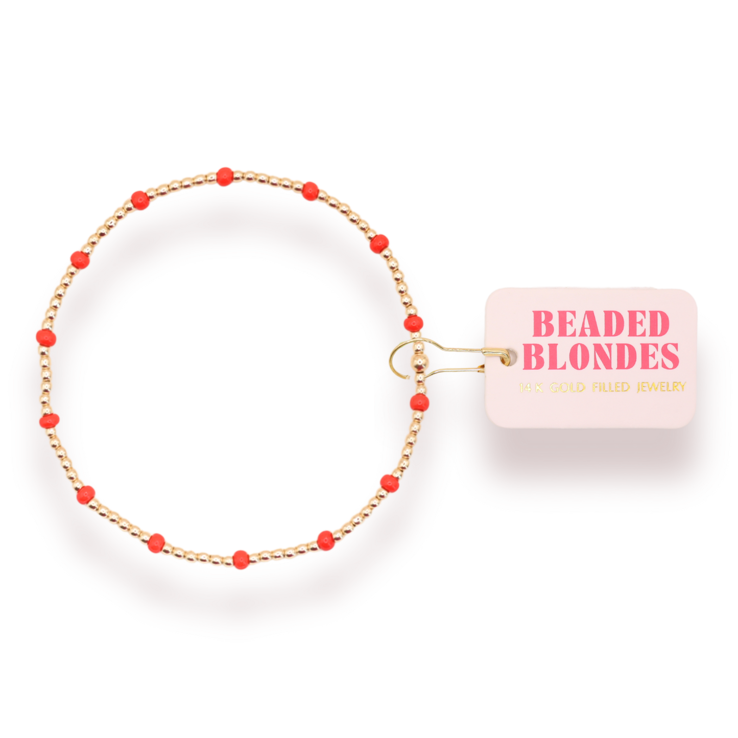 A gold-plated beaded bracelet with small red beads spaced along the chain, shown on a white background with a pink tag that reads 'BEADED BLONDES'.