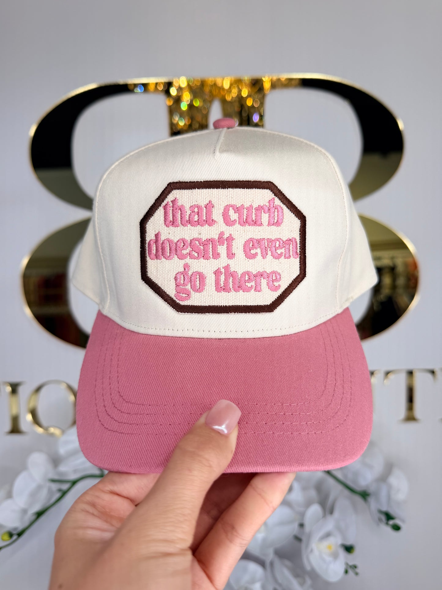 Trucker hat that is a soft pink with that curb doesn’t even go there