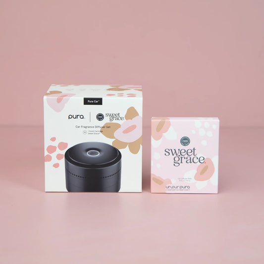 Pura car fragrance diffuser set with packaging on a pink background