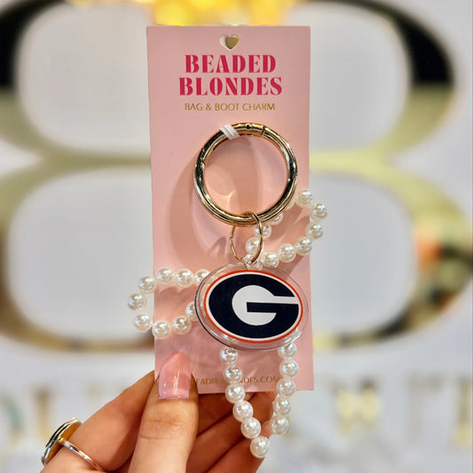 Georgia logo charm and white pearl bow on a gold-tone clip ring, held on a Beaded Blondes display card.