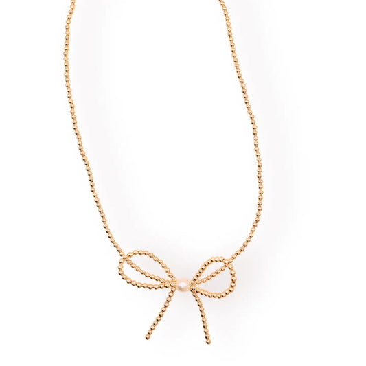 Gold beaded necklace with a bow-shaped centerpiece against a white background.
