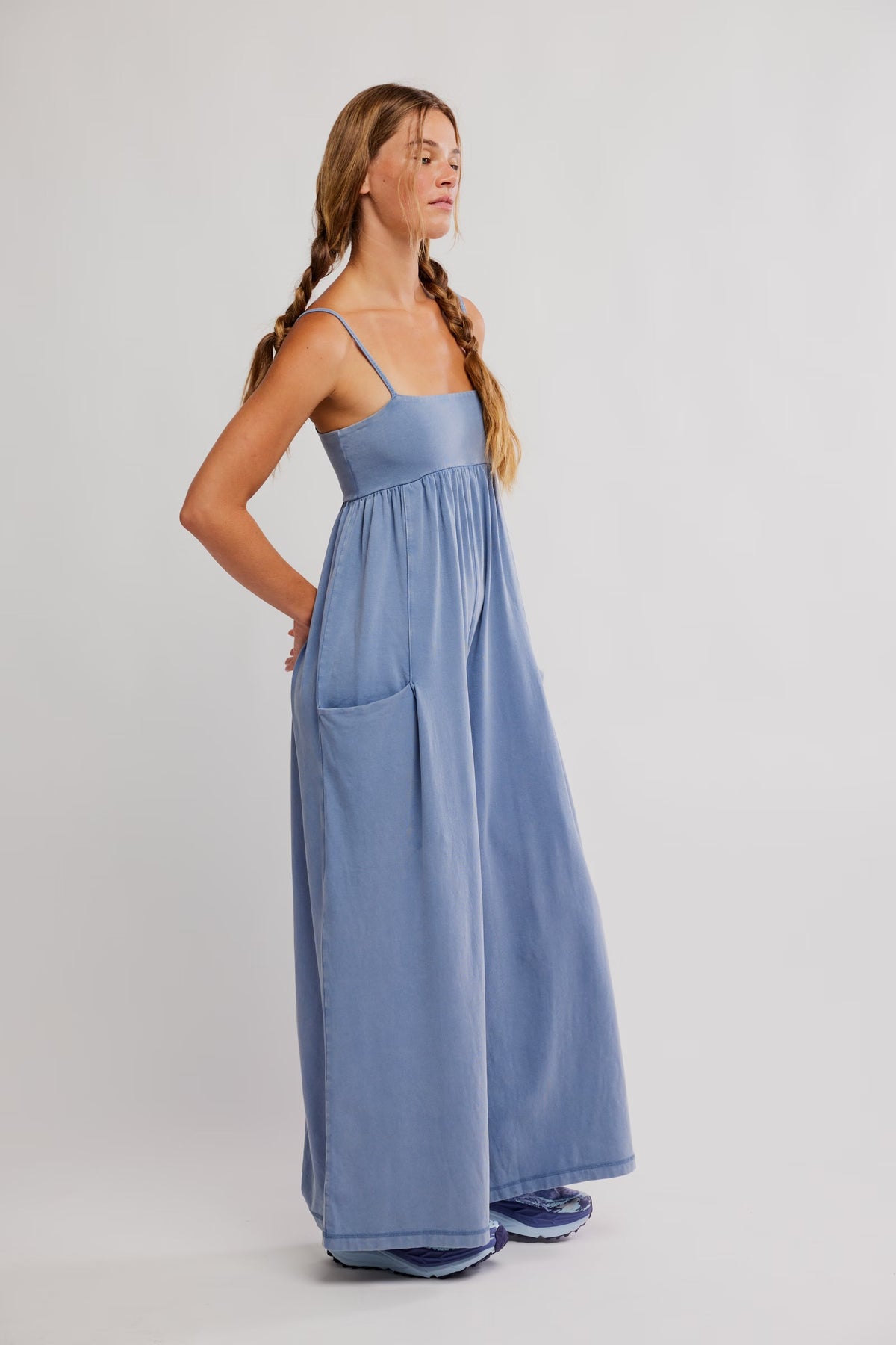 Woman wearing a long blue dress against a white background