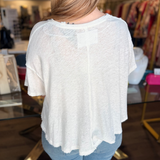 Person wearing a white blouse with sheer back panels in a store setting