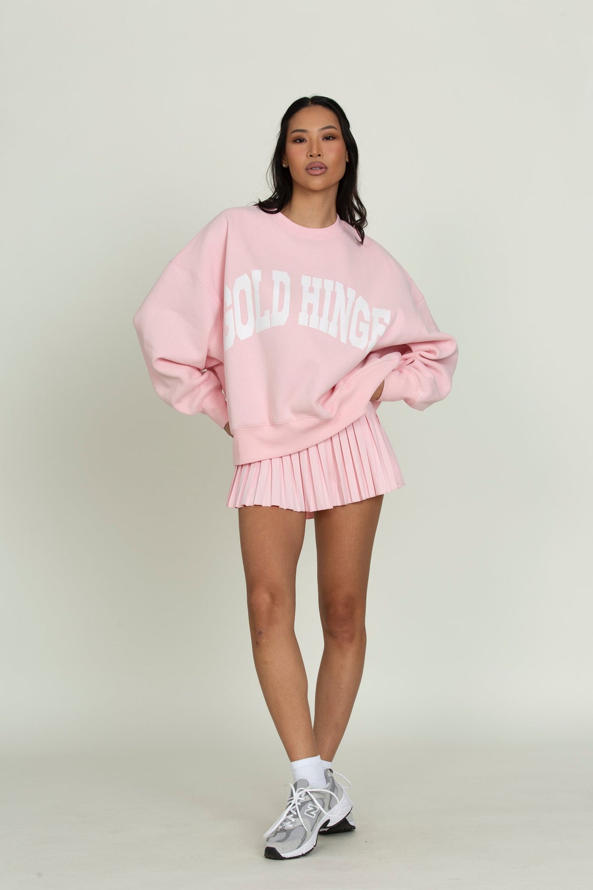 Model wearing Gold Hinge GH Wide Arm Sweatshirt in Almond Blossom with matching pleated skirt