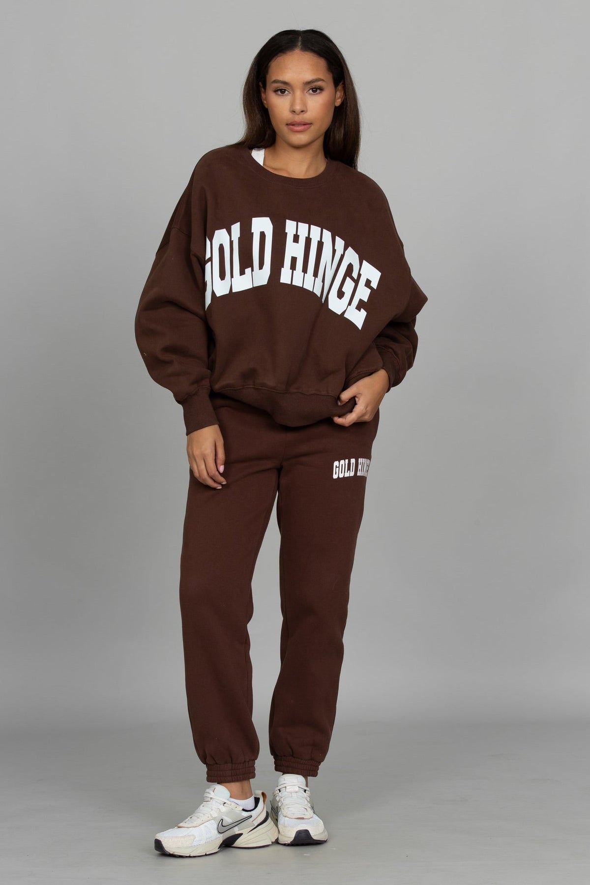 Model wearing Gold Hinge GH Wide Arm Sweatshirt in Dark Brown with matching joggers