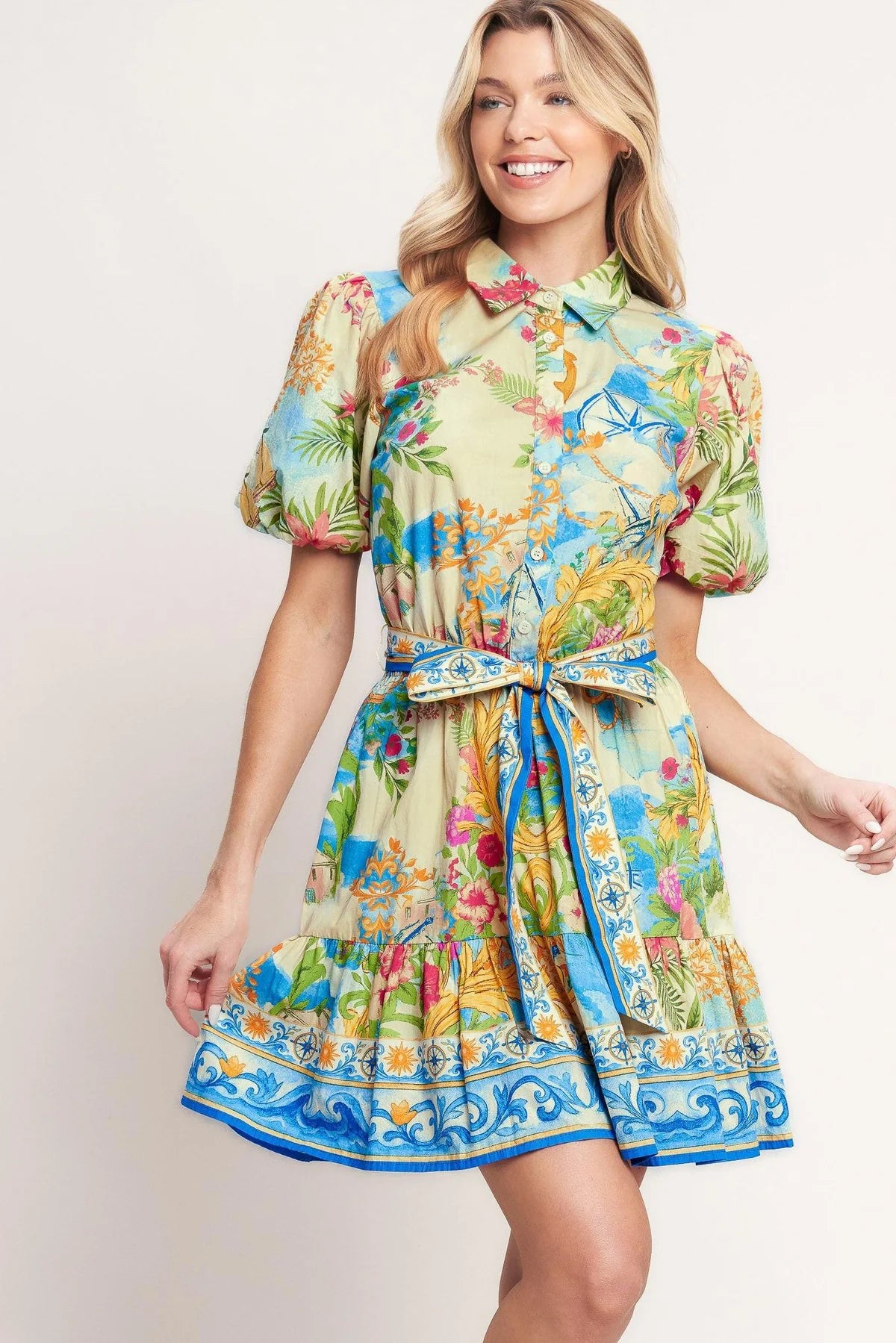 Woman wearing a colorful floral dress on a plain background