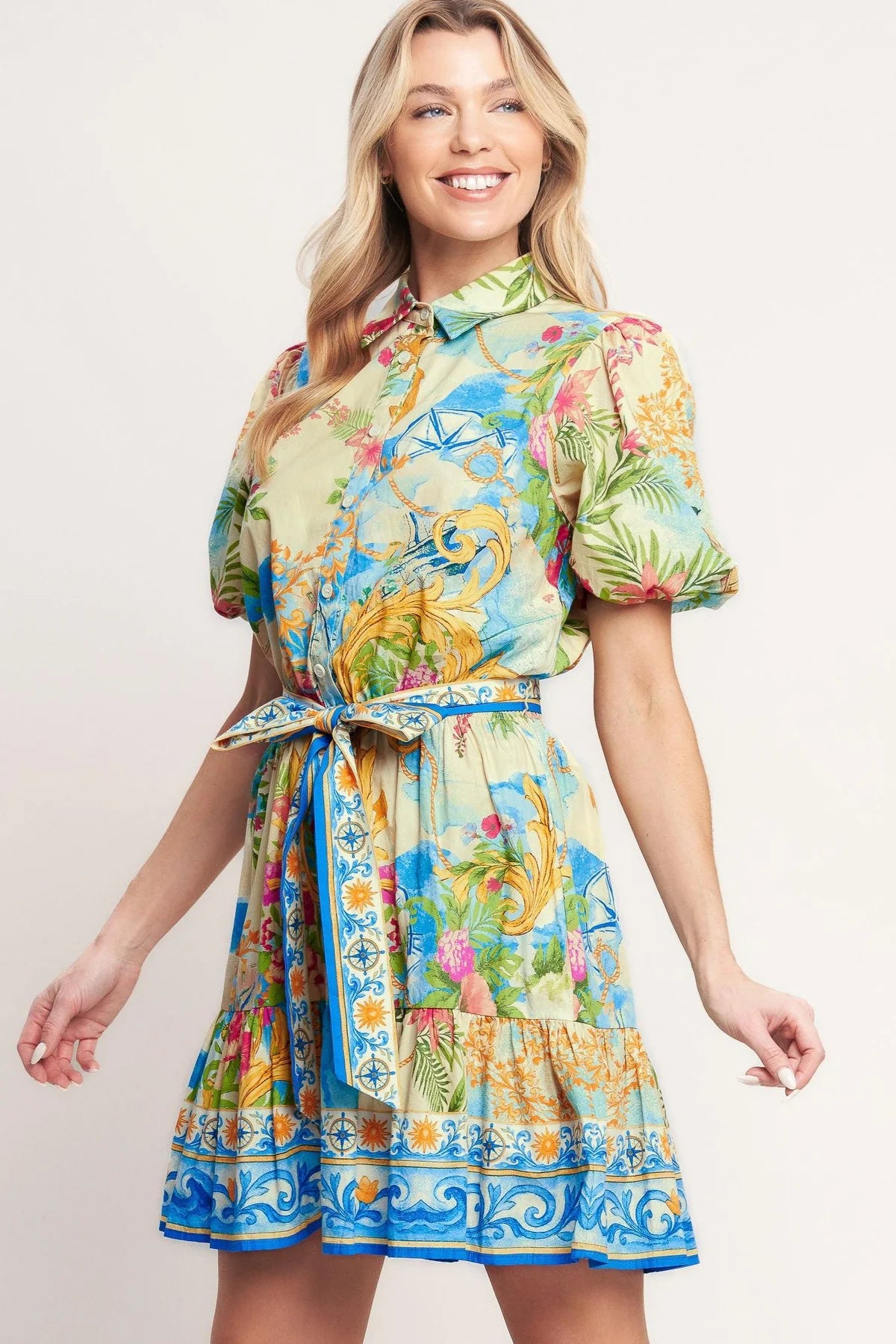 Woman wearing a colorful floral dress on a plain background