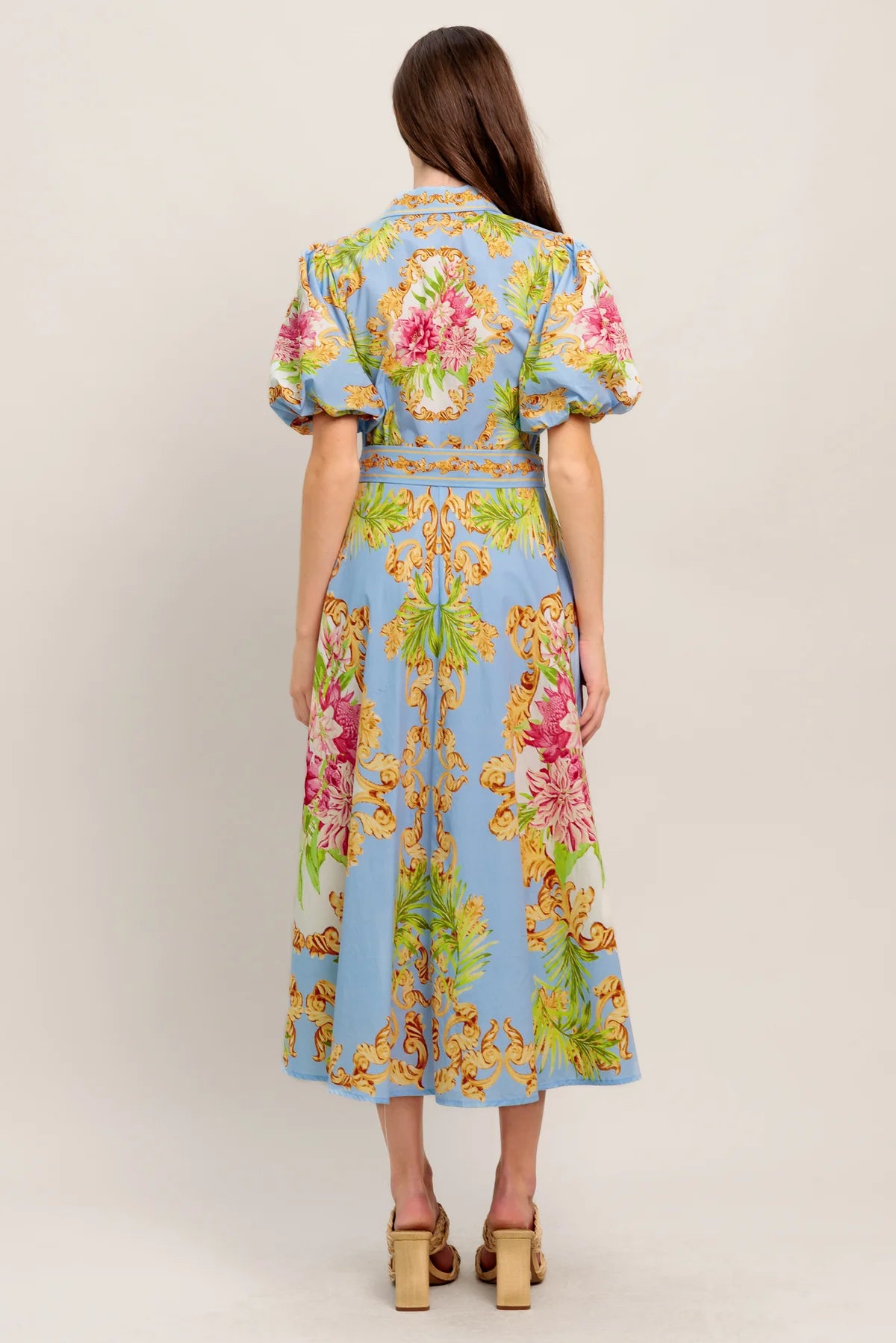 Woman wearing a colorful floral dress with a light blue background