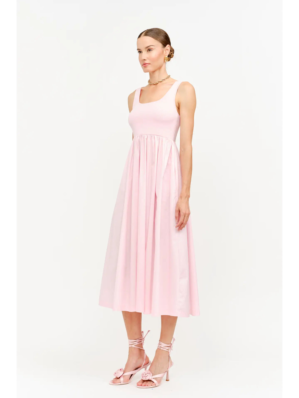 model wearing a pink maxi dress standing to the side