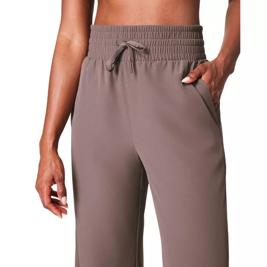 Brown Spanx brand drawstring pants worn by a person on a white background