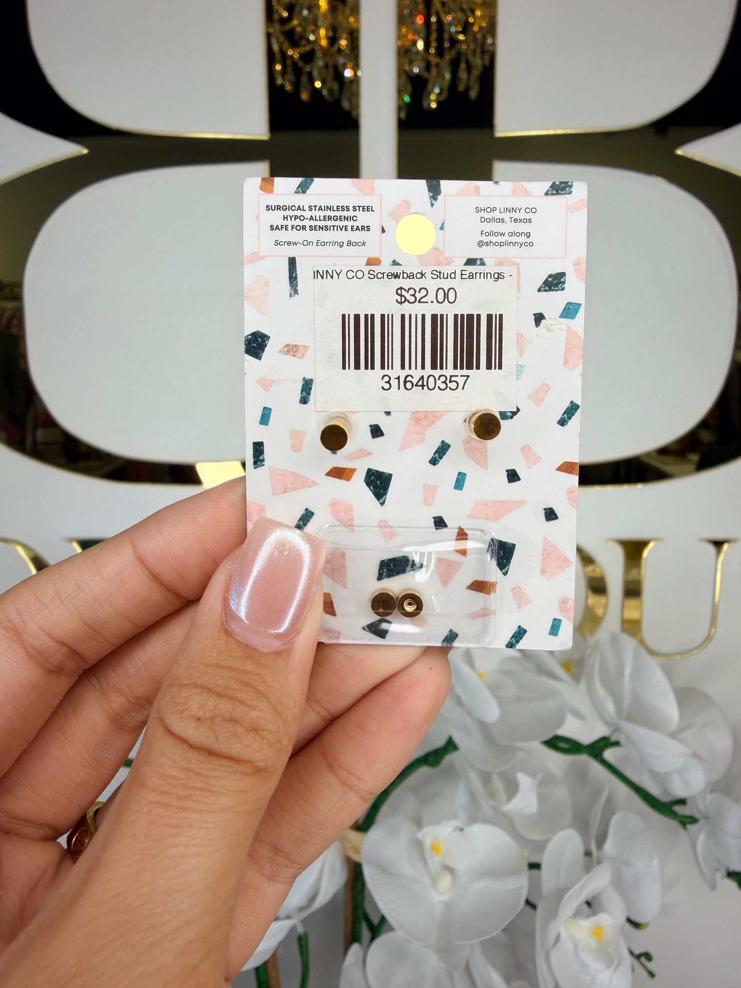 Back of Linny co earrings infront of BB sign