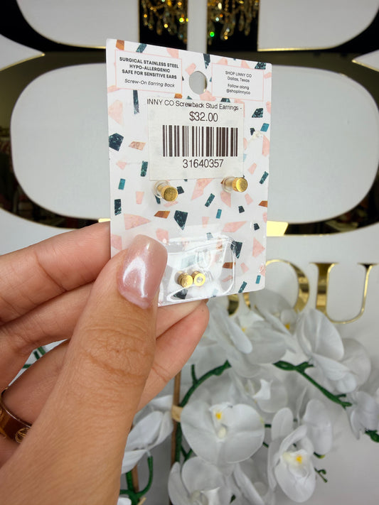 Hand holding a package of gold stud earrings with a decorative label.