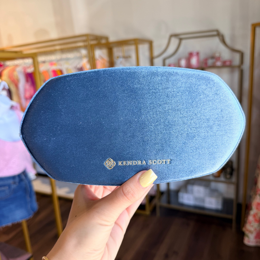 Blue Kendra Scott jewelry box in front of store
