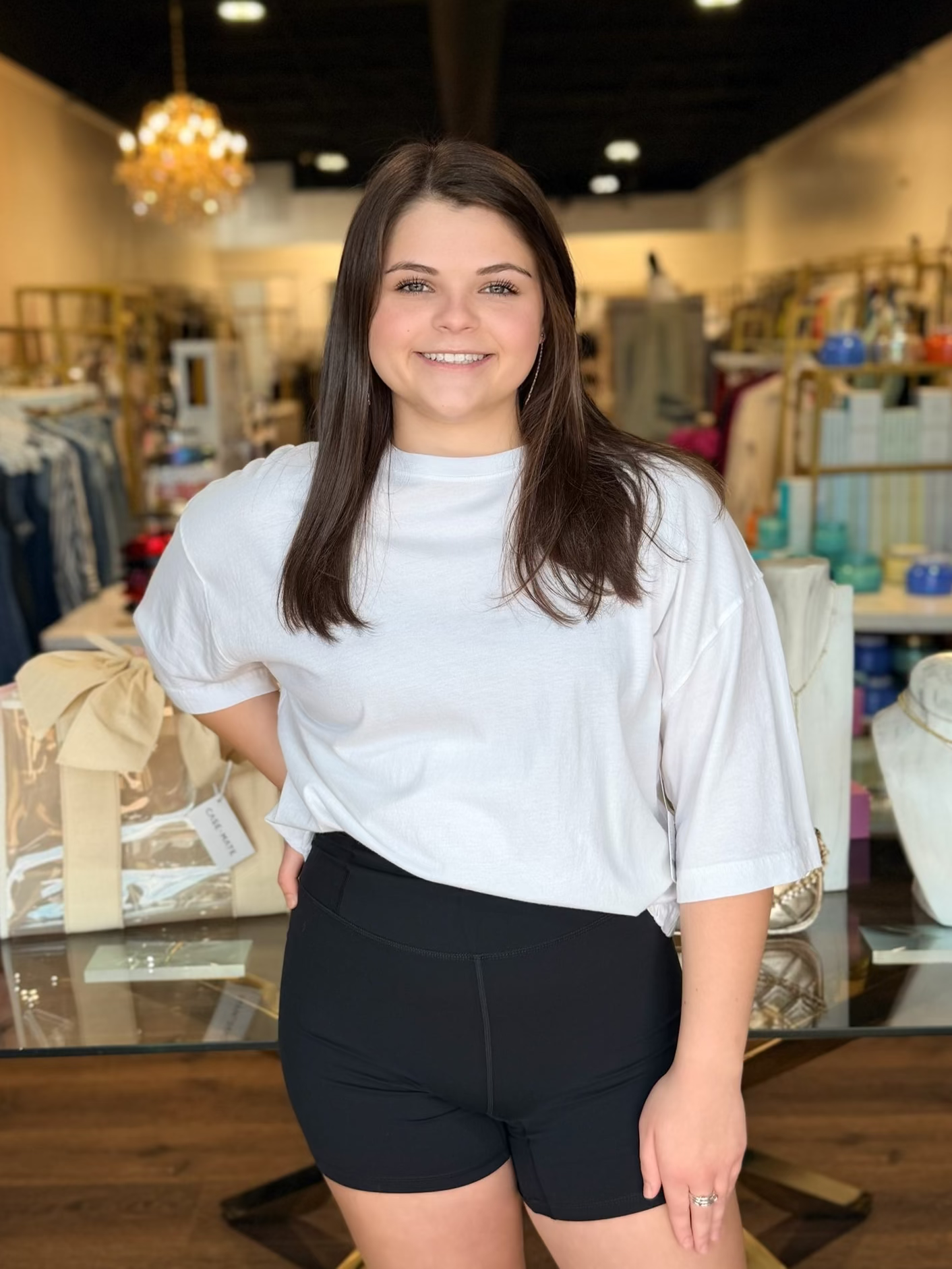 Model standing infront of store with white shirt and black biker shorts