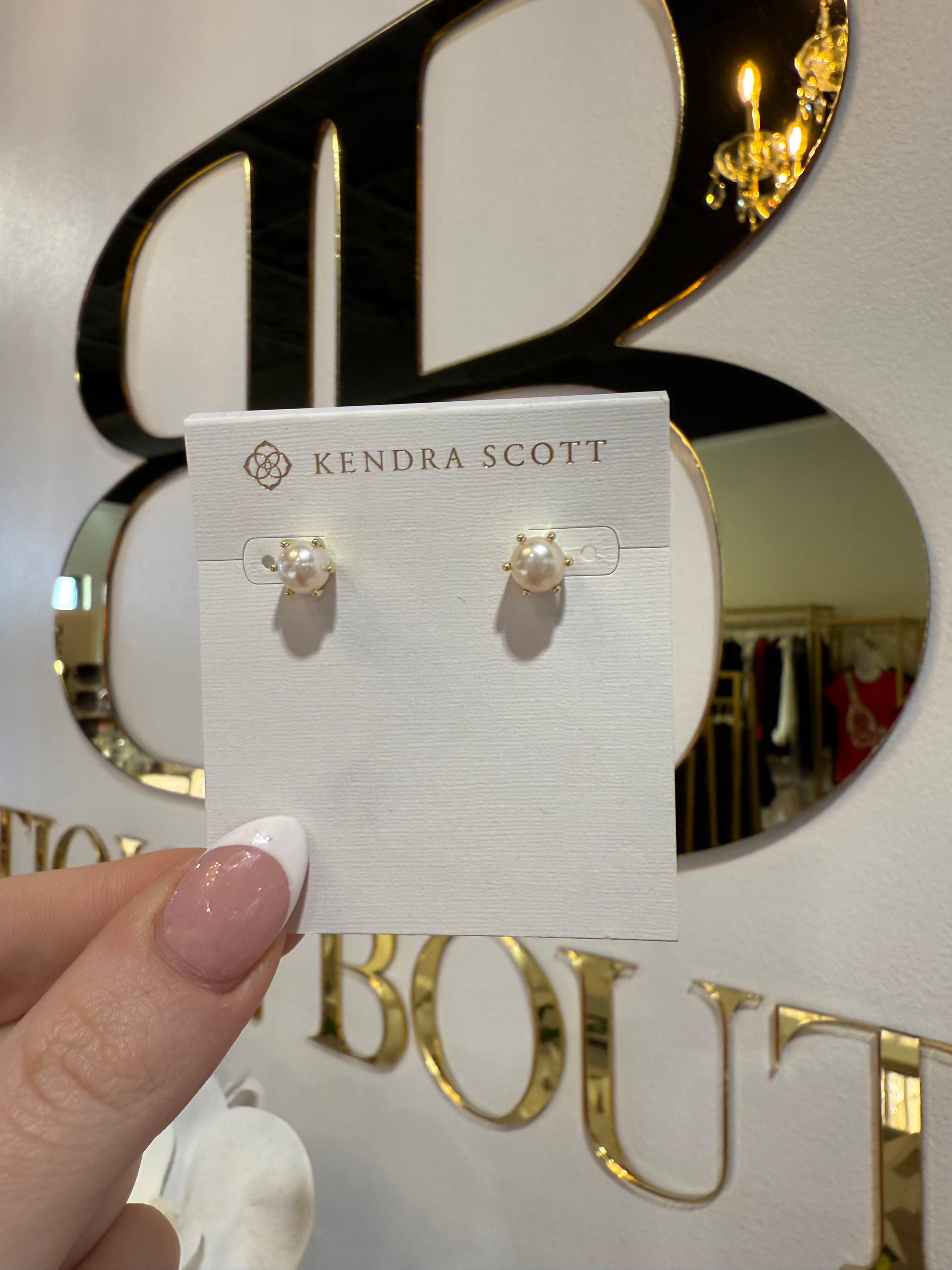 BOUTIQUE KENDRA SCOTT ASHTON GOLD PEARL STUD EARRINGS IN HAND