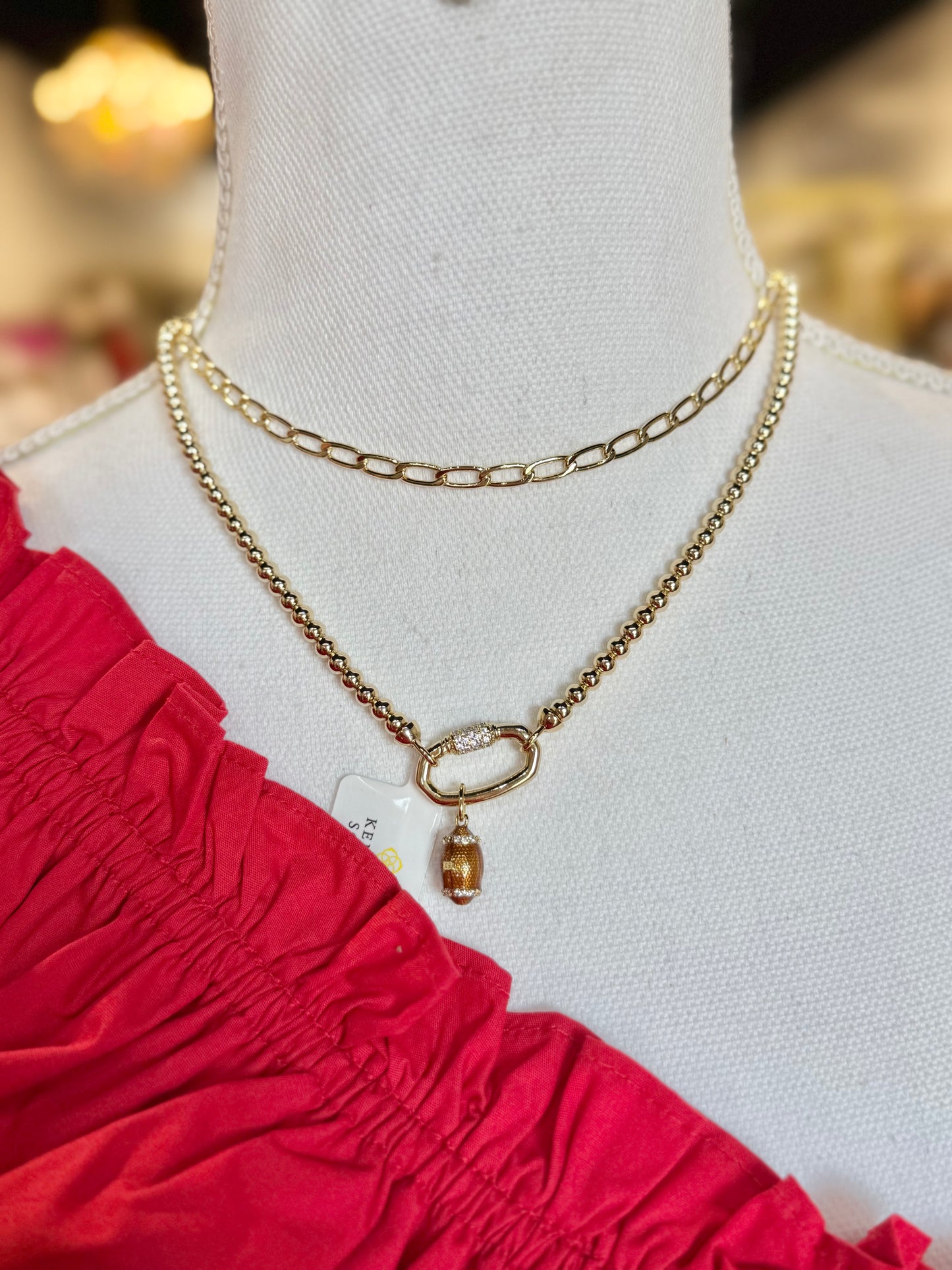 BOUTIQUE KENDRA SCOTT FOOTBALL GOLD METAL STRAND NECKLACE ON NECK