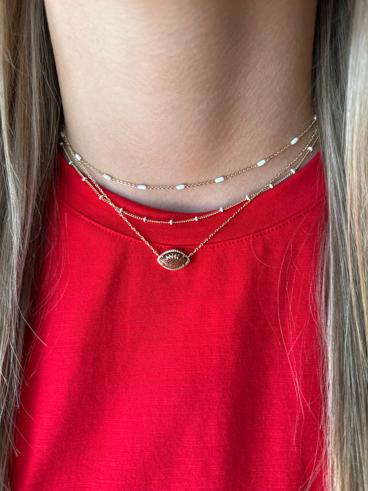 BOUTIQUE KENDRA SCOTT FOOTBALL GOLD SHORT PENDANT NECKLACE IN ORANGE GOLDSTONE ON MODEL