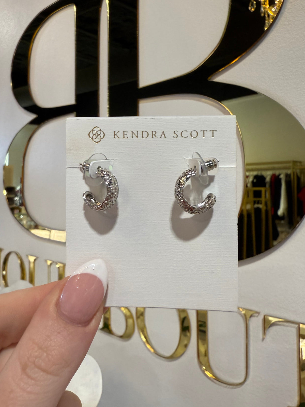 BOUTIQUE KENDRA SCOTT SILVER HARPER HUGGIE EARRING IN HAND