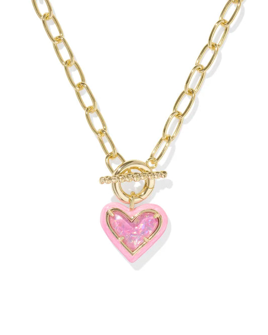A gold Kendra Scott Ari Heart Enamel Frame Link Chain necklace with a gold heart-shaped pendant encased in pink enamel, featuring a toggle closure.