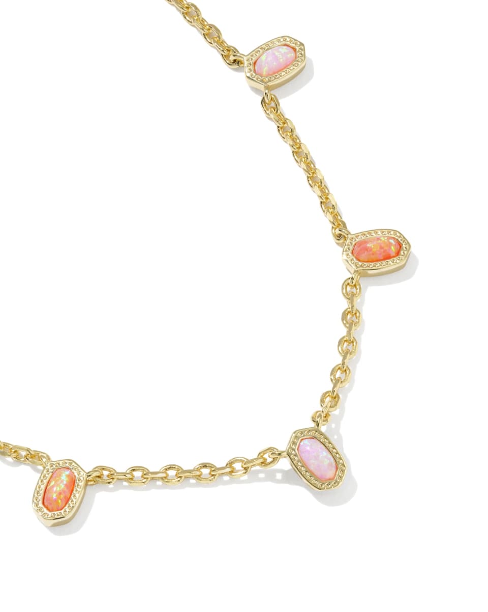 Gold necklace with pink gemstones on a white background