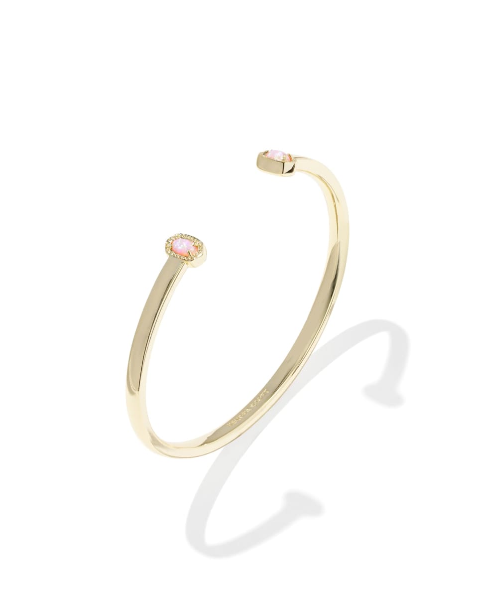 Gold bracelet with a pink gemstone on a white background