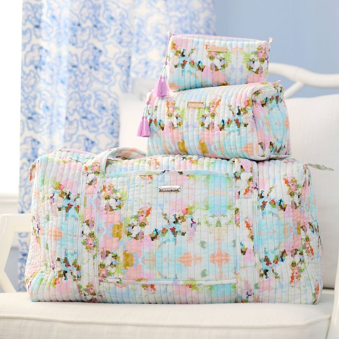 Floral Laura Park travel bag set on a white chair with a light blue background