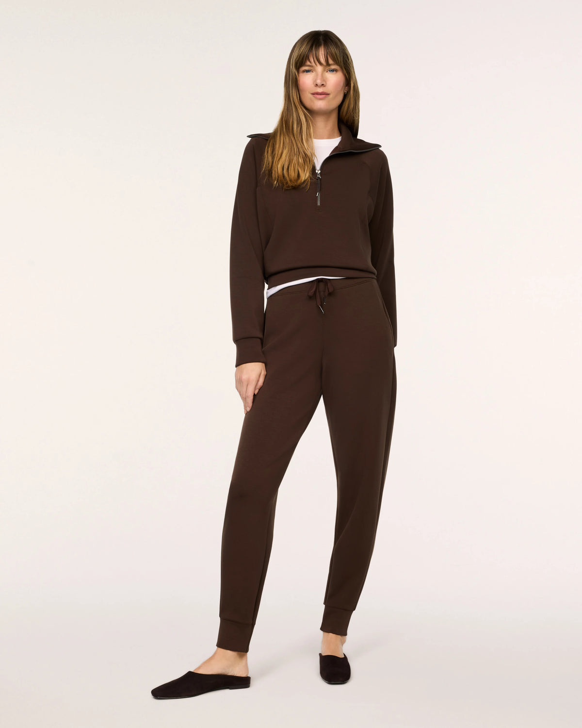 Model wearing Spanx Half Zip Umber Root with white background.