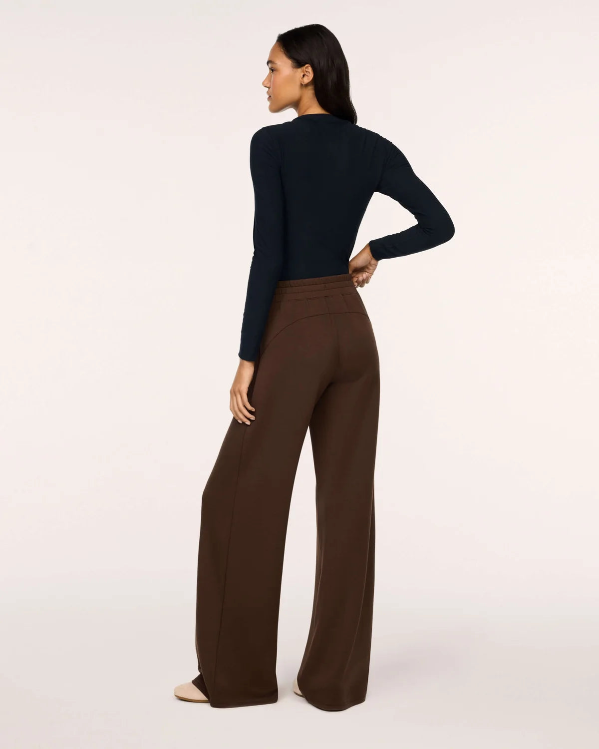 Model wearing Spanx Wide Leg Pants Umber Root back view with white background.