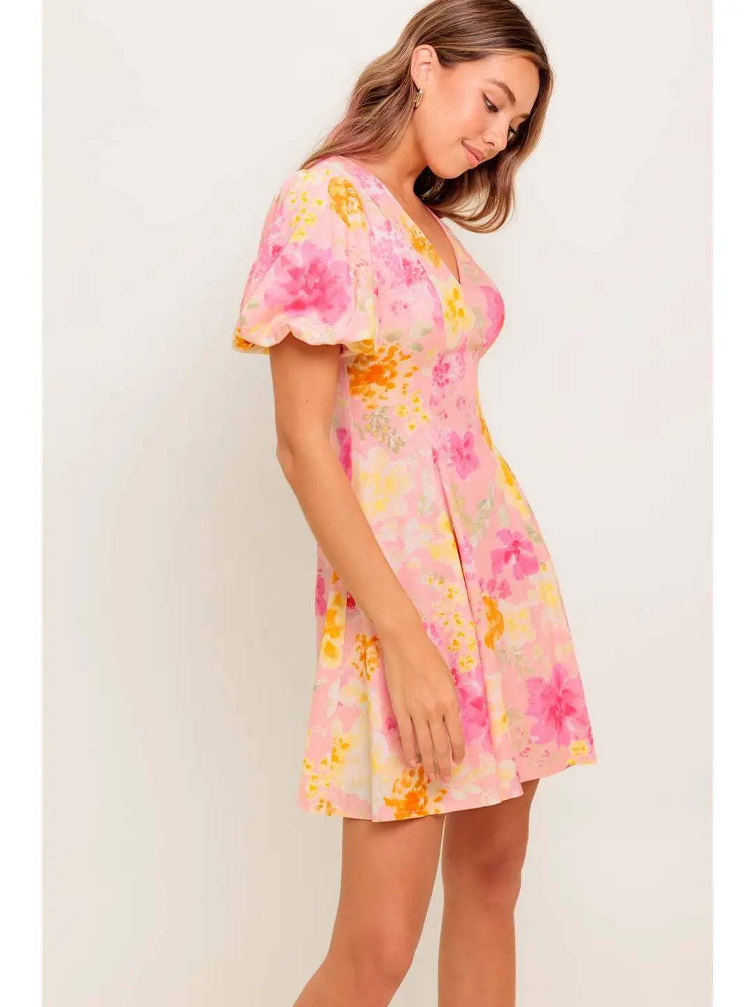 Woman wearing a pink floral dress against a white background