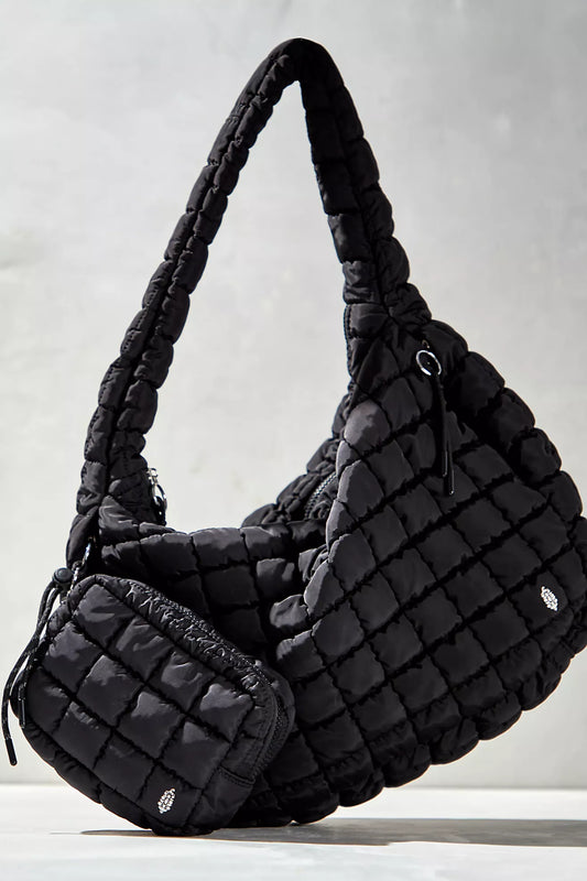 Black quilted handbag on a light gray background
