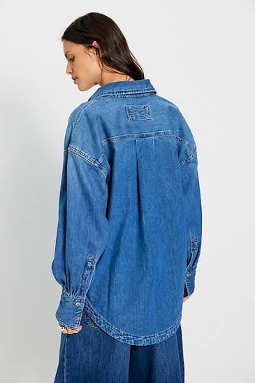 Person wearing a blue denim jacket on a white background