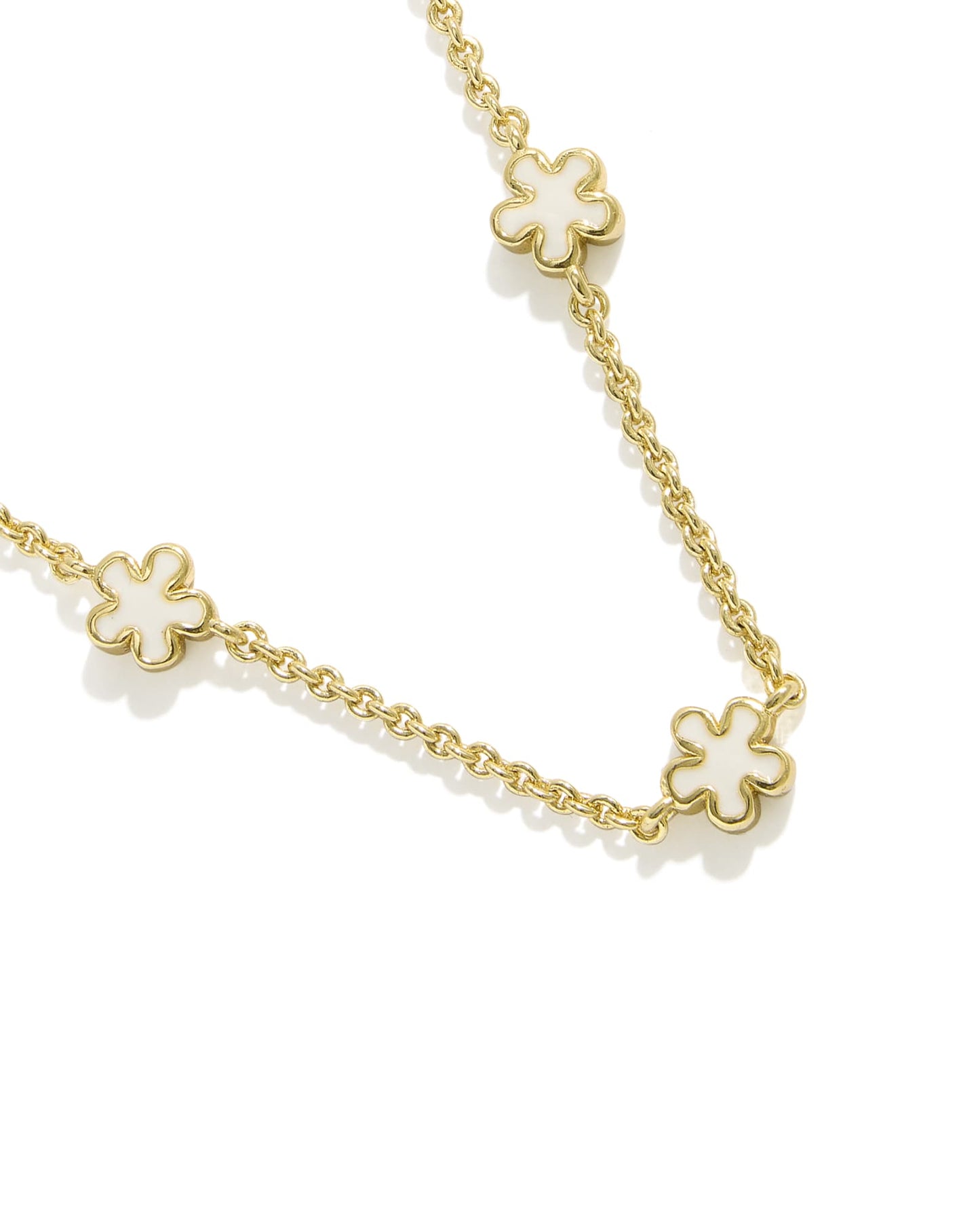 gold strand necklace with white flowers close up