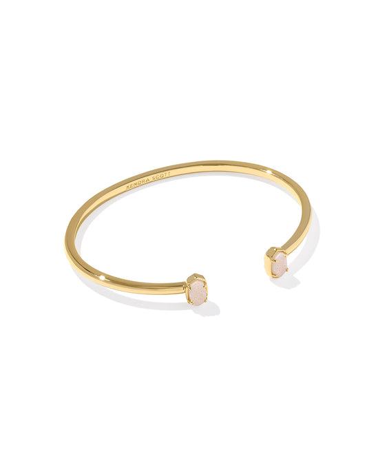 Gold bracelet with a small round gemstone on a white background