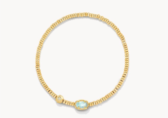 Gold bracelet with a central blue gemstone on a white background