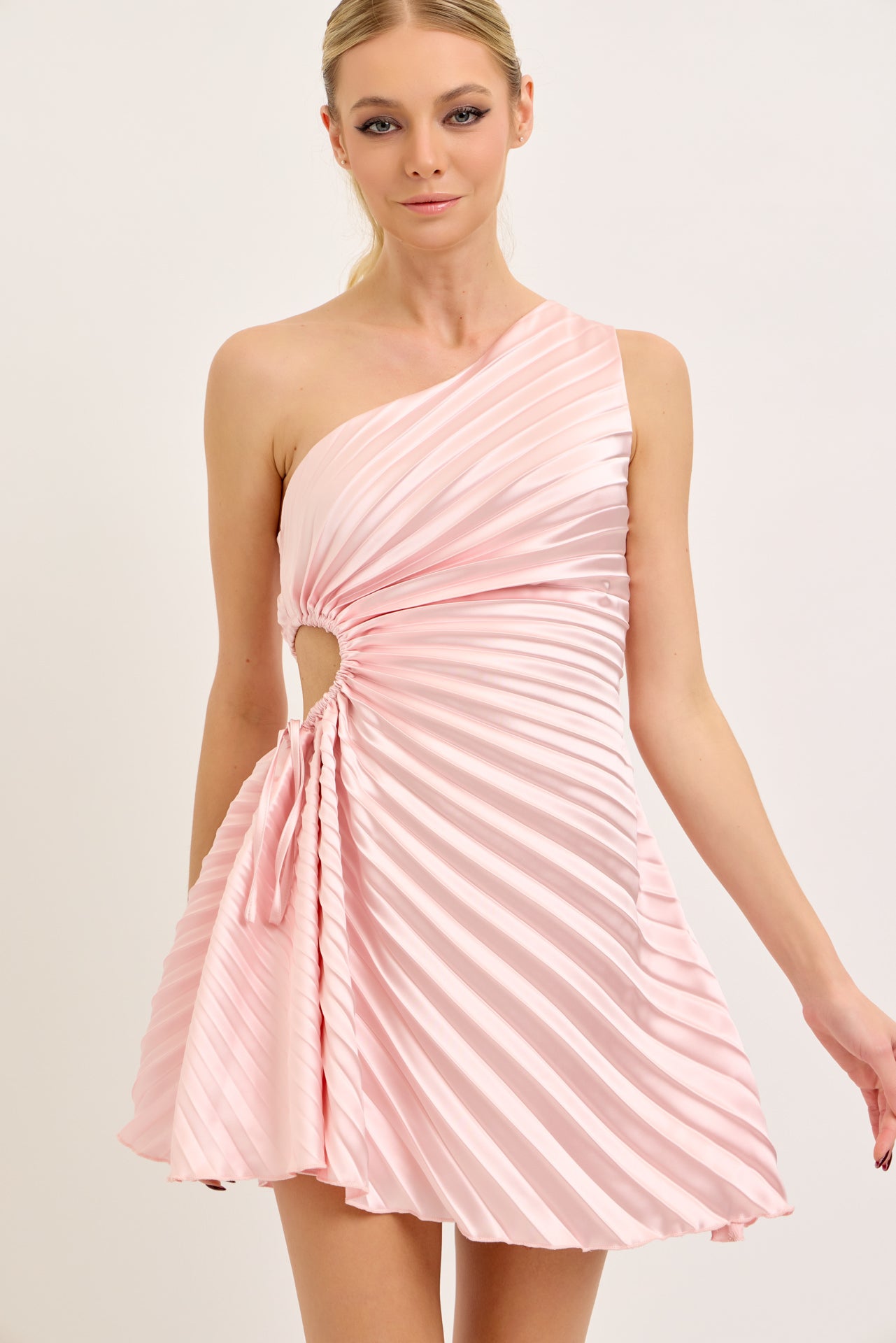 Woman wearing a pink one-shoulder dress on a white background