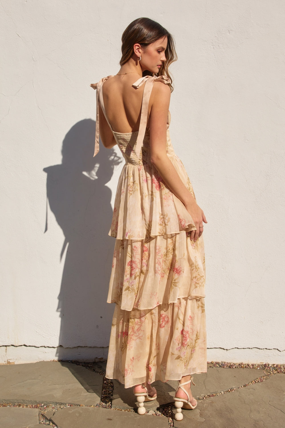 Woman wearing a floral dress with a white wall background