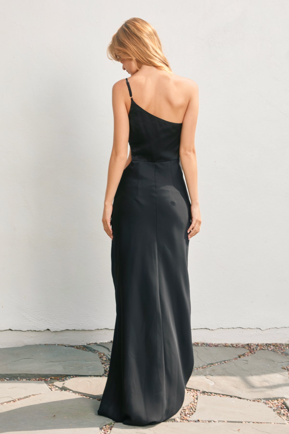 Woman wearing a black evening gown against a plain background