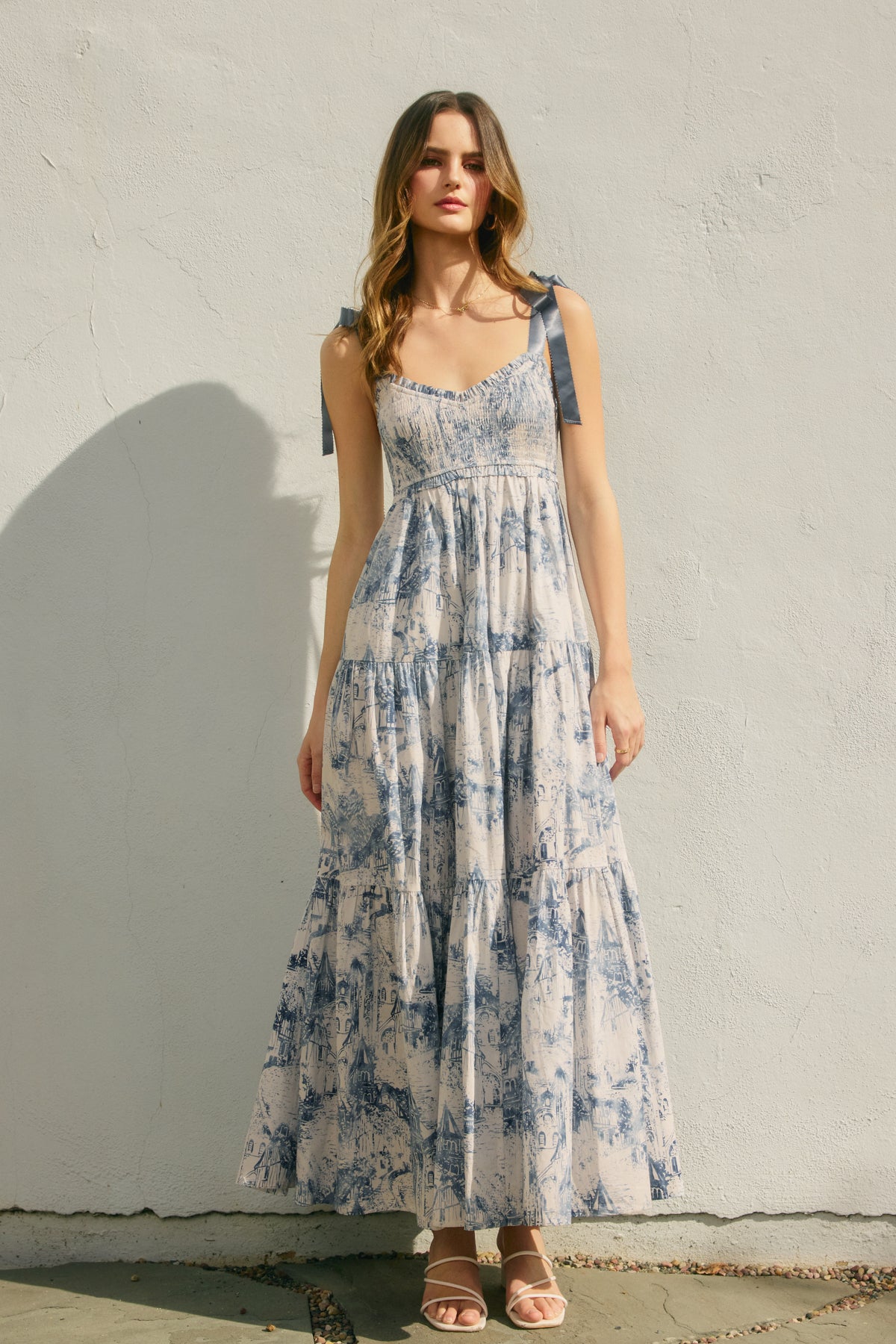 Woman wearing a floral dress against a plain wall