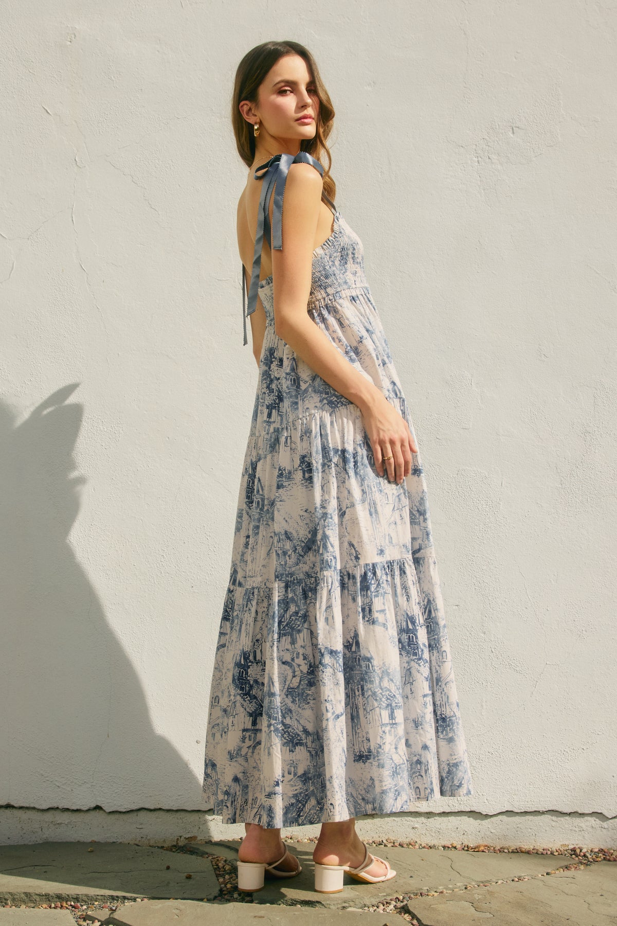 Woman wearing a floral dress against a white wall