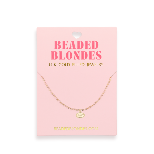 Gold necklace on a pink card with 'Beaded Blondes' branding