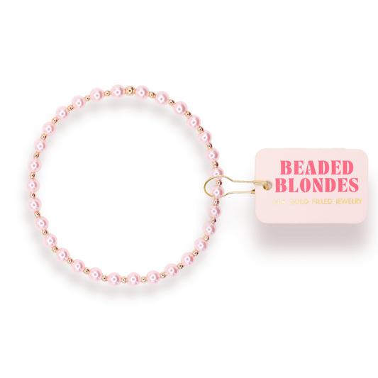Pink beaded hair tie with 'Beaded Blondes' packaging on a white background